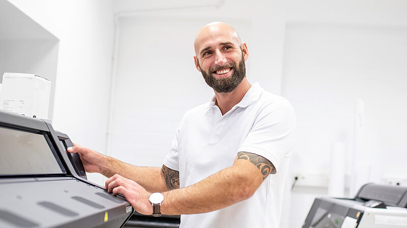 lächelnder Mann bedient eine Maschine